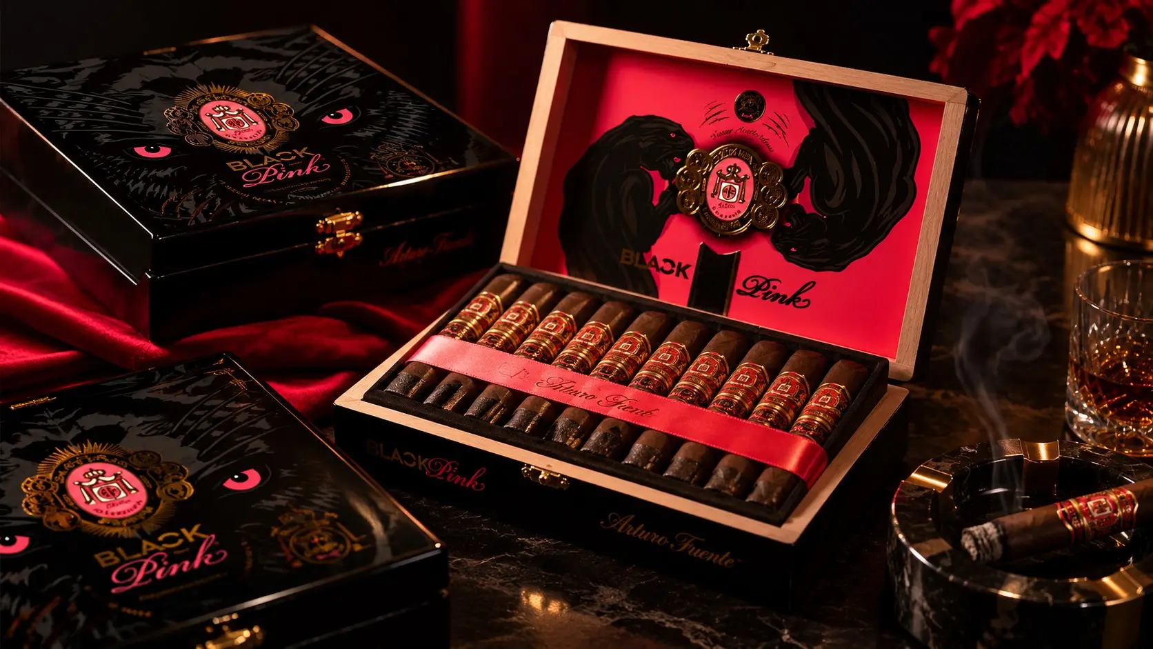 Arturo Fuente Black Pink boxes, one open with its cigars and a pink ribbon